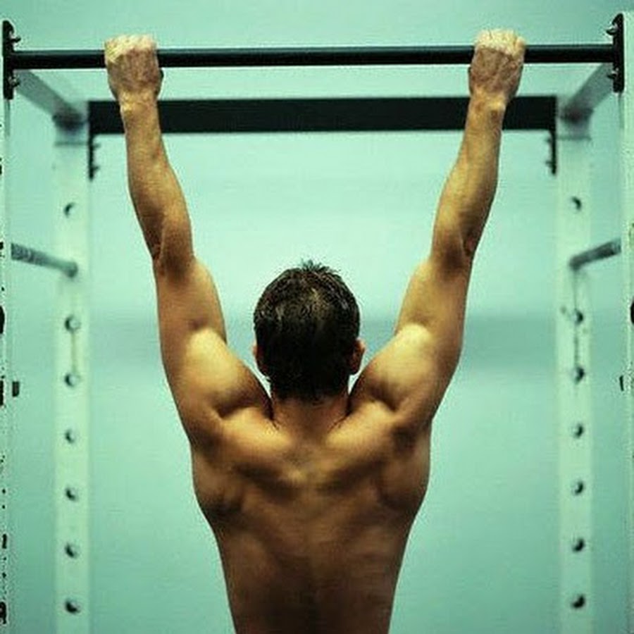 Не нравится спорт. Подтягивания на турнике. Турник в спортзале. Мужчина подтягивается. Парень висит на турнике.