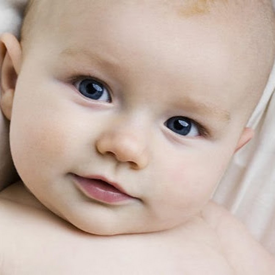 Ребеноксуд на белом фоне. Улыбка новорожденного. А к малыш. Грудной ребенок. Красивые младенцы.