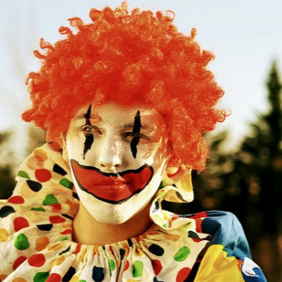 Хочешь быть клоуном. Клоун. Радостный клоун. Клоун с оранжевыми волосами. Клоун в парке.